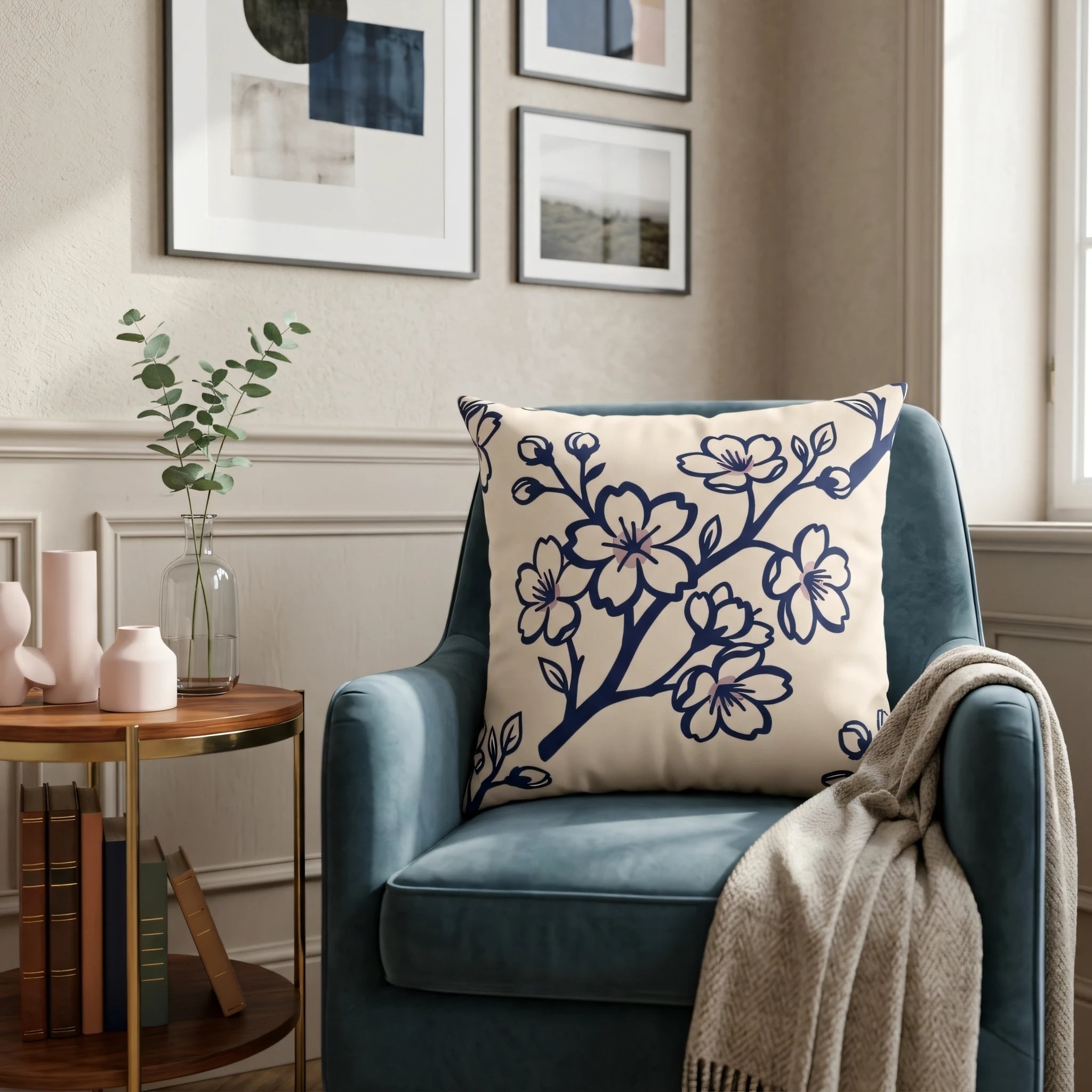 Cream throw pillow featuring a navy blue blossom design resting on a blue armchair in a cozy, decorated living room.