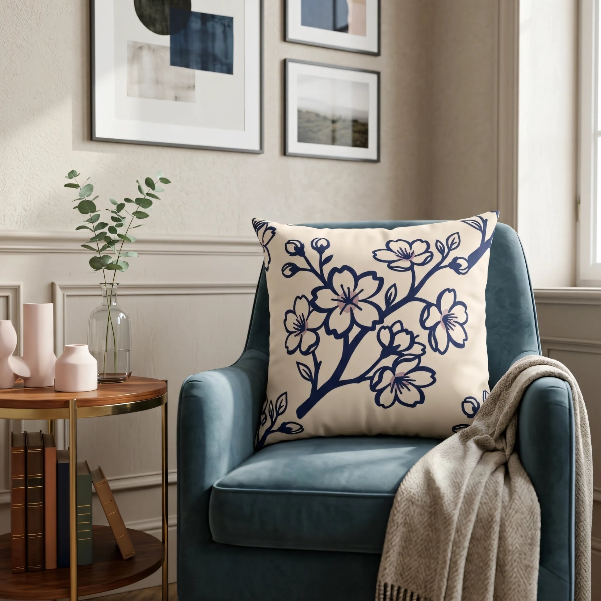 Cream throw pillow featuring a navy blue blossom design resting on a blue armchair in a cozy, decorated living room.