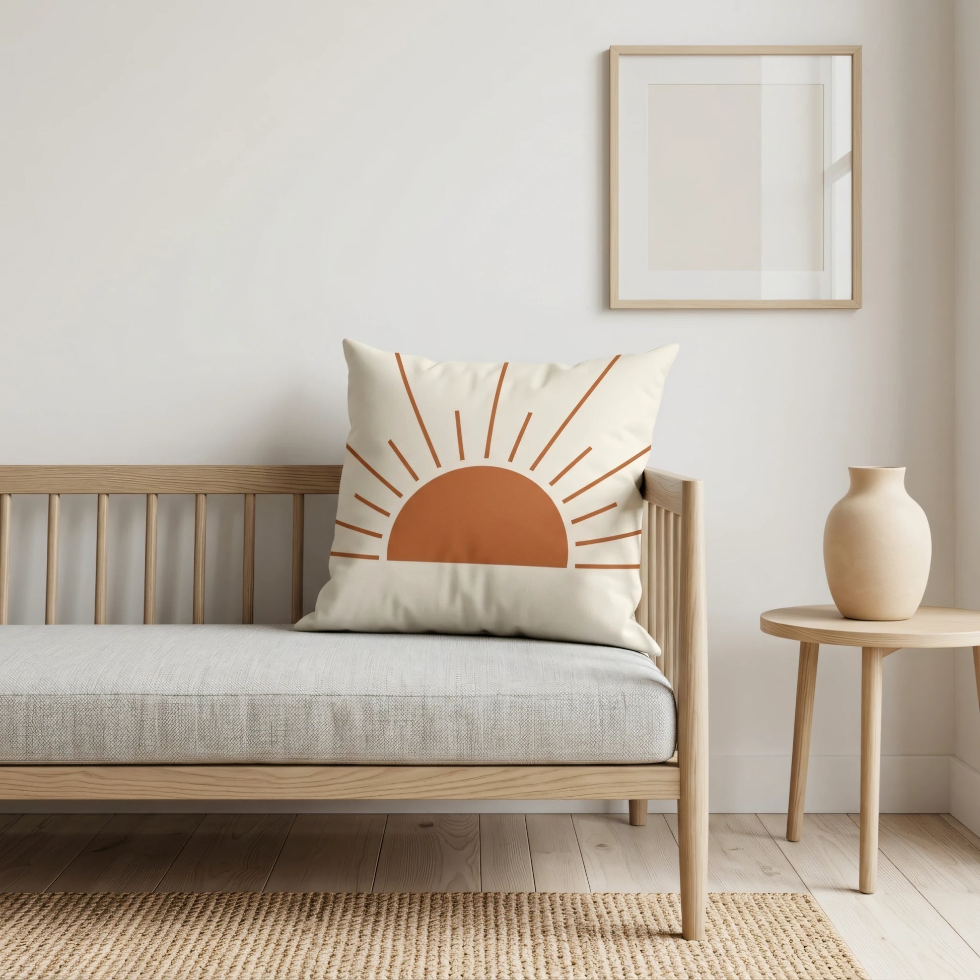 Terracotta sun print cushion on a light wood sofa in a minimalist room with a side table and neutral tones, perfect for modern home decor.