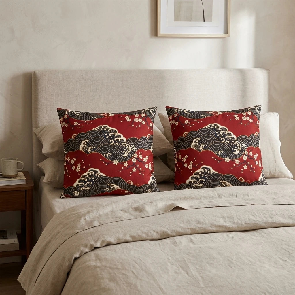 Pair of red Japanese wave and cherry blossom print cushions on a beige bed with linen bedding in a minimalist bedroom setting.