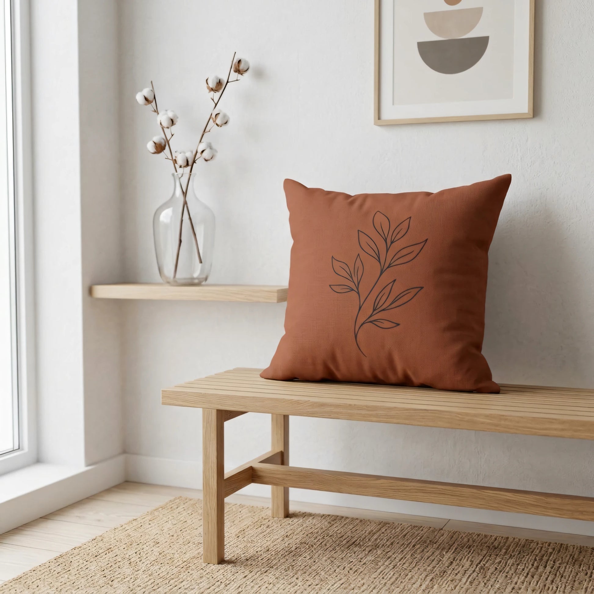 Terracotta throw pillow with a black botanical line art design on a wooden bench in a minimalist interior with natural decor.